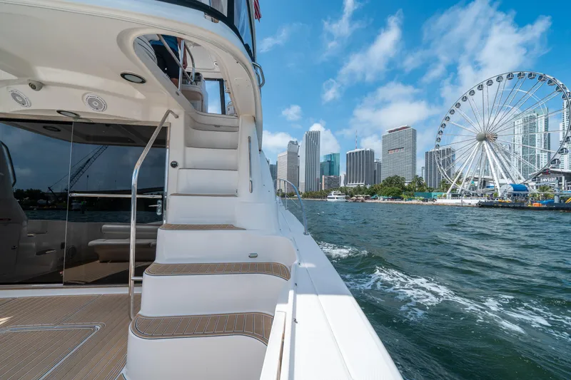 Slide: The Image of 2006 Sea Ray 58 Sedan Bridge yacht cruising near city skyline and Ferris wheel. - 29