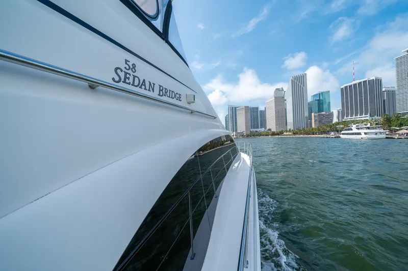 Slide: The Image of Sea Ray 58 Sedan Bridge yacht cruising near city skyline, 2006 model. - 31
