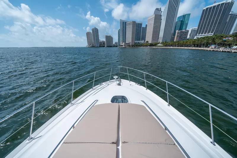 Slide: The Image of 2006 Sea Ray 58 Sedan Bridge yacht cruising near city skyline. - 34