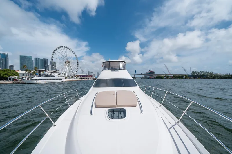 Slide: The Image of 2006 Sea Ray 58 Sedan Bridge yacht cruising near city skyline and Ferris wheel. - 35