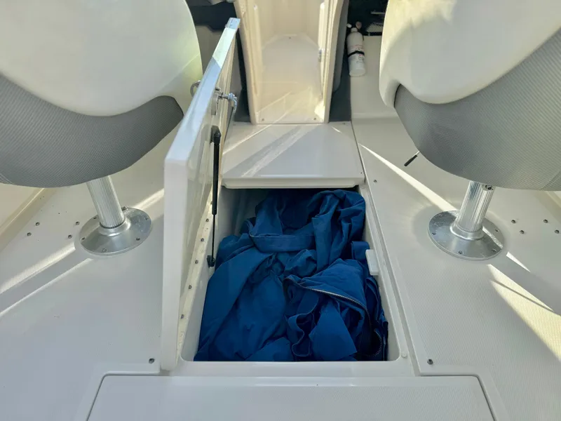 Slide: The Image of 2008 Sea Ray 230 Select Fission boat storage compartment with blue fabric inside. - 18