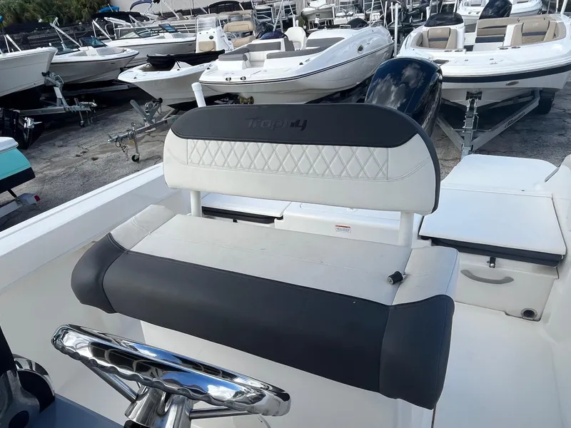 Slide: The Image of 2022 Bayliner Trophy T22CC boat interior with cushioned seating and steering wheel. - 4