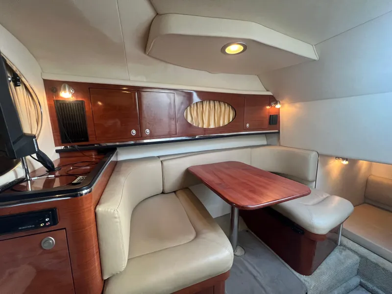 Slide: The Image of 2007 Sea Ray 290 Amberjack cabin interior with dining area and wooden cabinetry. - 12