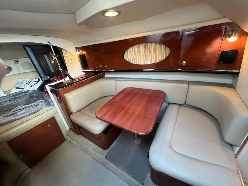 Slide: The Image of Interior of 2007 Sea Ray 290 Amberjack with cozy seating and wooden table. - 14