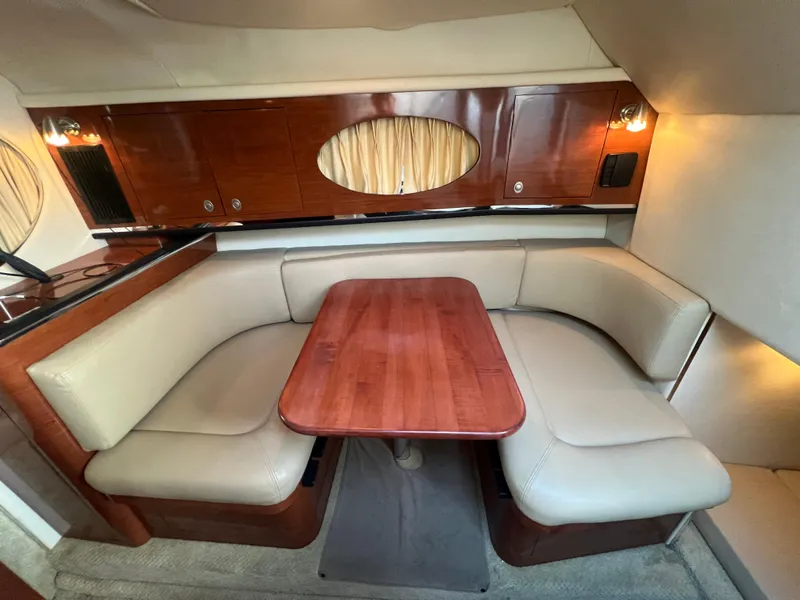 Slide: The Image of Interior of 2007 Sea Ray 290 Amberjack with wood table and beige seating. - 15