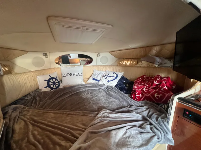 Slide: The Image of Interior of 2007 Sea Ray 290 Amberjack with cozy bedding and nautical-themed pillows. - 16