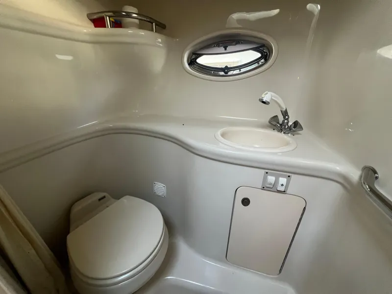 Slide: The Image of 2007 Sea Ray 290 Amberjack bathroom with toilet, sink, and porthole window. - 20