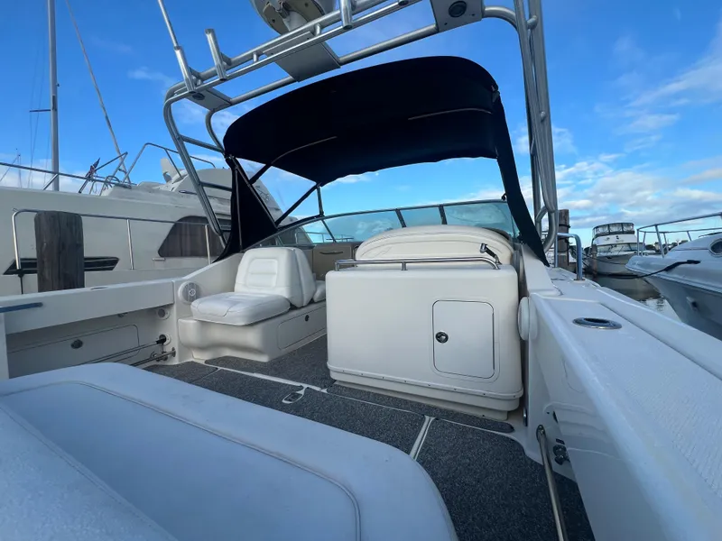 Slide: The Image of 2007 Sea Ray 290 Amberjack boat interior with seating and canopy under a clear blue sky. - 8