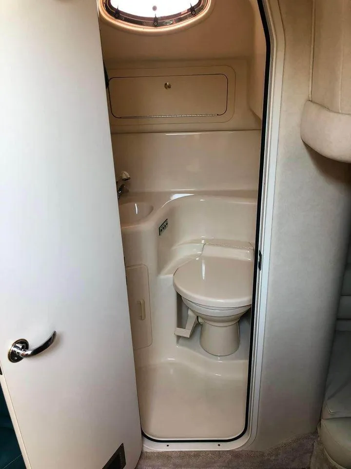 Slide: The Image of 1997 Sea Ray 400 Sundancer bathroom with compact toilet and sink. - 11