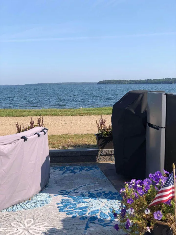 Slide: The Image of Scenic lakeside view with covered furniture, flowers, and American flag on a sunny day. - 18