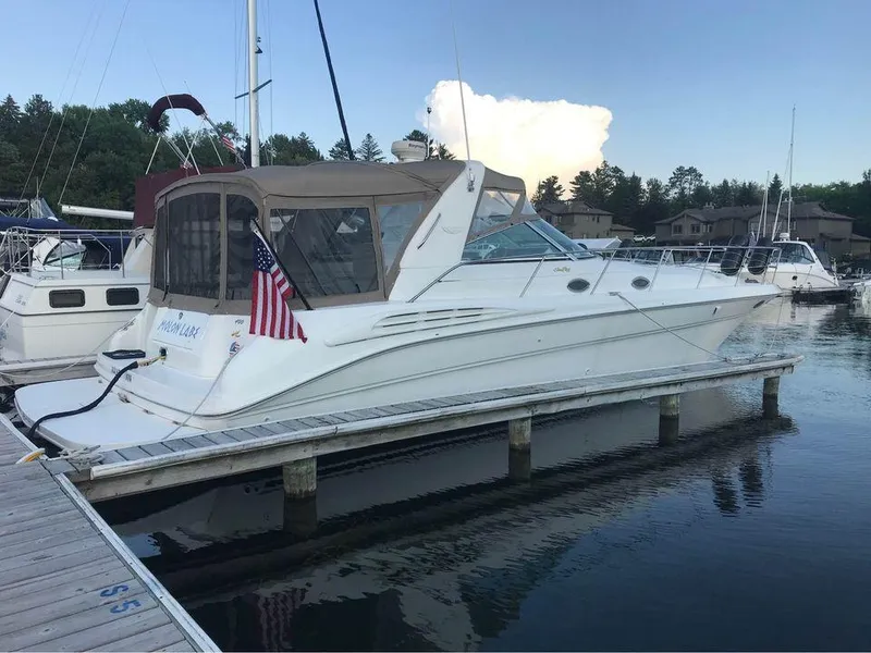 Slide: The Image of 1997 Sea Ray 400 Sundancer docked at marina with American flag. - 2