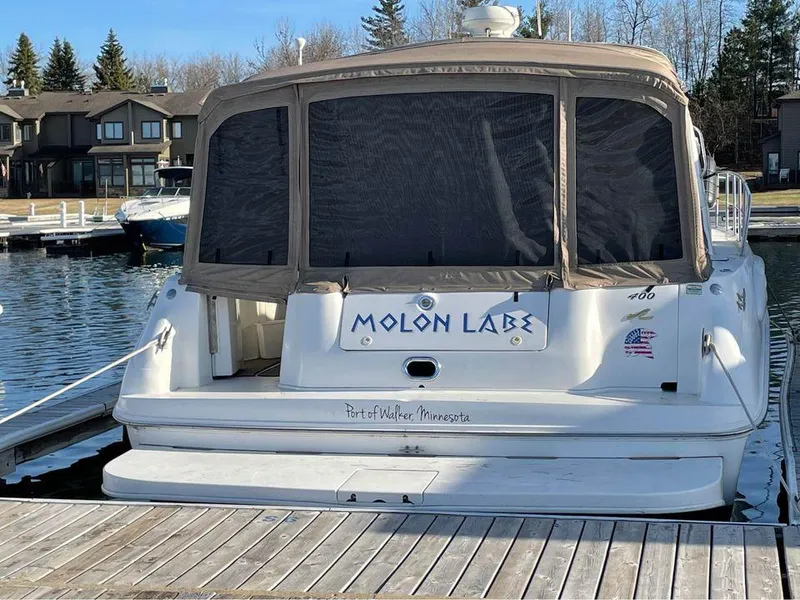 Slide: The Image of 1997 Sea Ray 400 Sundancer docked, rear view with "Molon Labe" text, calm marina setting. - 7