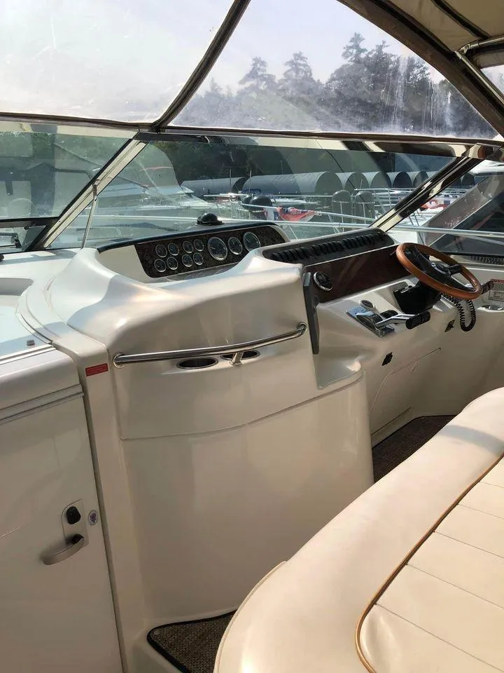 Slide: The Image of 1997 Sea Ray 400 Sundancer helm with wood-accented steering and modern controls. - 9