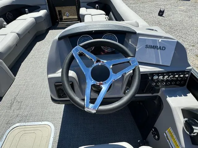 Slide: The Image of 2025 Barletta Aria 24UC boat dashboard with steering wheel and Simrad display. - 18