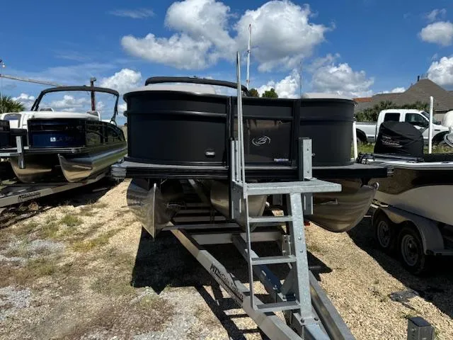 Slide: The Image of 2025 Barletta Aria 24UC pontoon boat on trailer under a clear blue sky. - 3