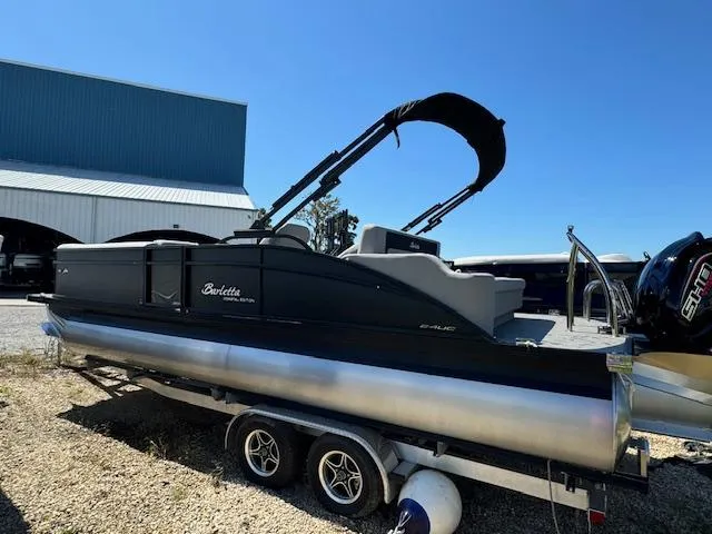Slide: The Image of 2025 Barletta Aria 24UC pontoon boat on trailer, parked outdoors. - 5