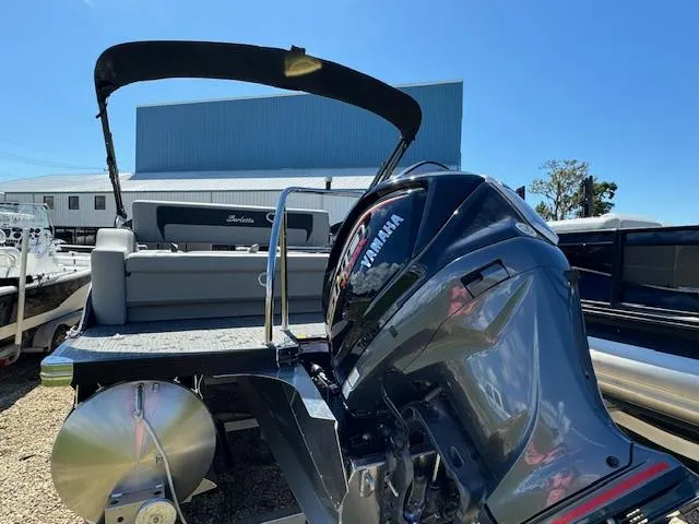 Slide: The Image of 2025 Barletta Aria 24UC pontoon boat with Yamaha outboard motor, docked outdoors. - 7