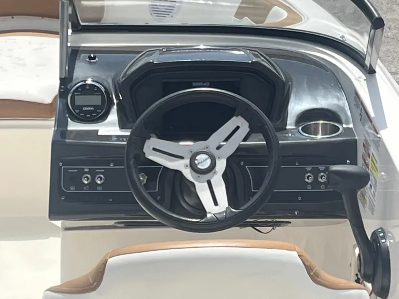 Slide: The Image of 2021 Bayliner VR6 boat dashboard with steering wheel and control panel. - 2