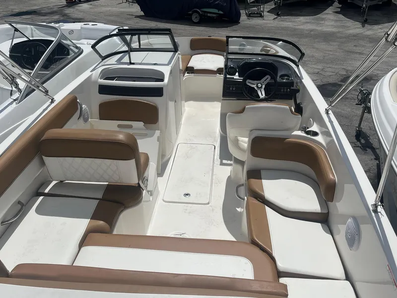 Slide: The Image of 2021 Bayliner VR6 boat interior with tan and white seating, steering wheel, and dashboard. - 4