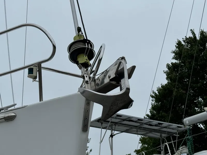 Slide: The Image of Beneteau Oceanis 37 sailboat anchor detail, 2008 model, with rigging and greenery in background. - 11