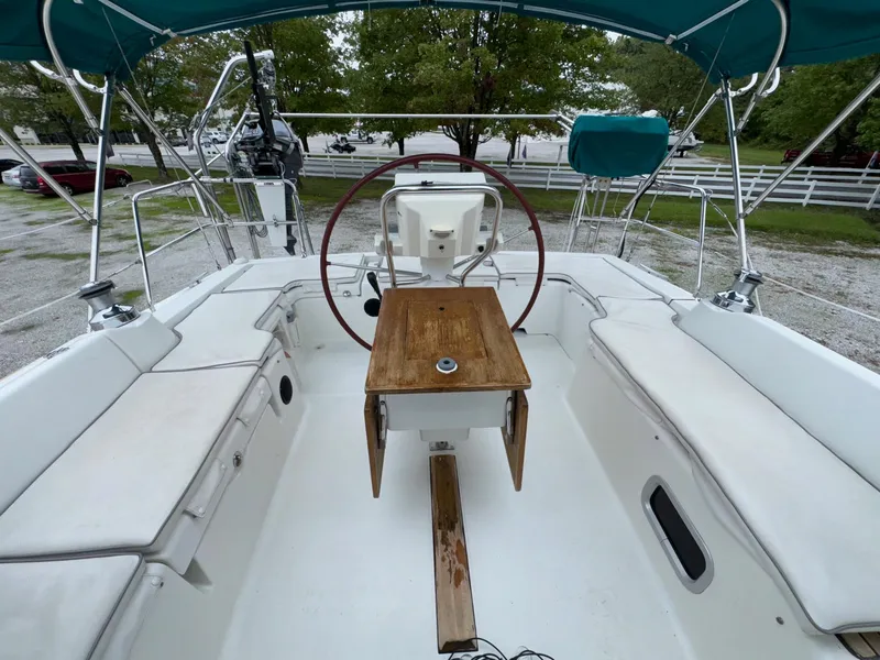Slide: The Image of 2008 Beneteau Oceanis 37 sailboat cockpit with wooden table and steering wheel. - 16