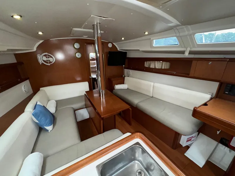 Slide: The Image of Interior of 2008 Beneteau Oceanis 37 sailboat with cozy seating and wooden finishes. - 2
