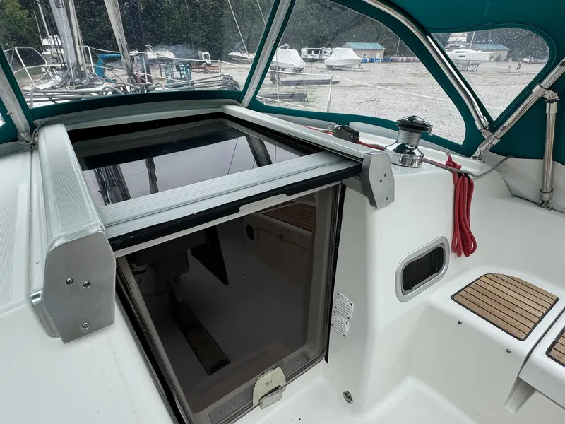 Slide: The Image of 2008 Beneteau Oceanis 37 sailboat cockpit with open hatch and green canopy. - 26