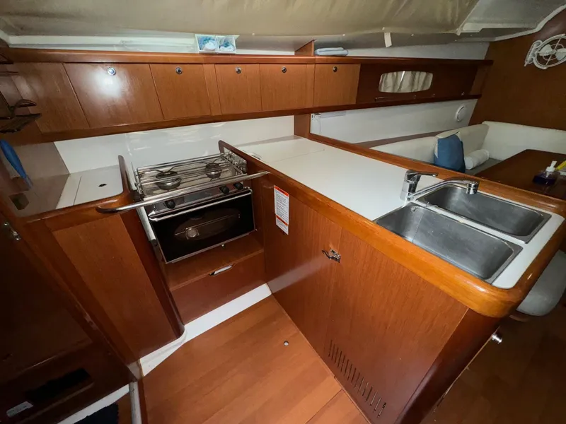 Slide: The Image of Interior of 2008 Beneteau Oceanis 37 sailboat kitchen with wood cabinetry and dual sink. - 3