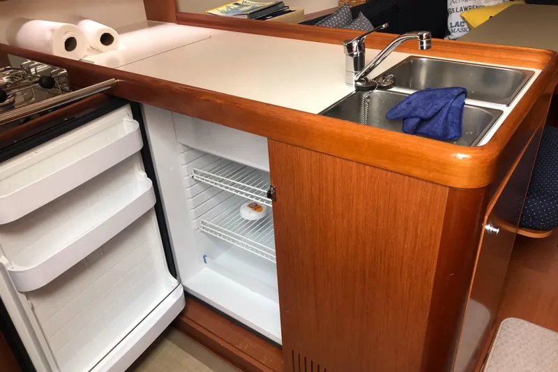 Slide: The Image of Beneteau Oceanis 37 yacht kitchen with sink, fridge, and wooden cabinetry, 2008 model. - 38
