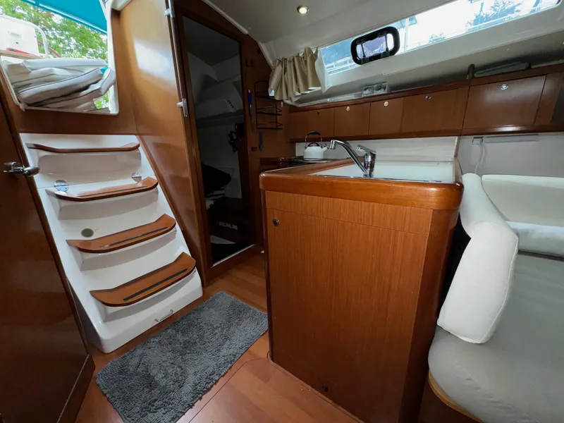Slide: The Image of Interior of 2008 Beneteau Oceanis 37 sailboat with wooden cabinetry and compact kitchen. - 44