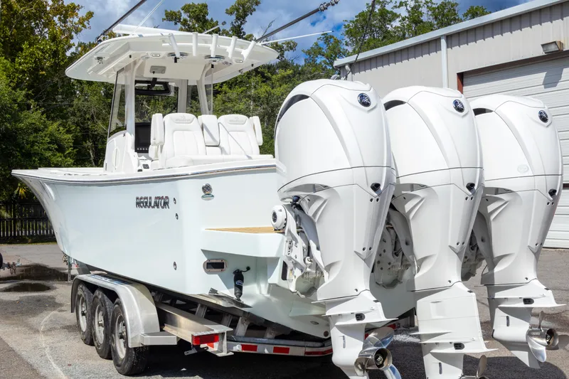 Slide: The Image of 2023 Regulator 34 boat with triple outboard engines on a trailer. - 10