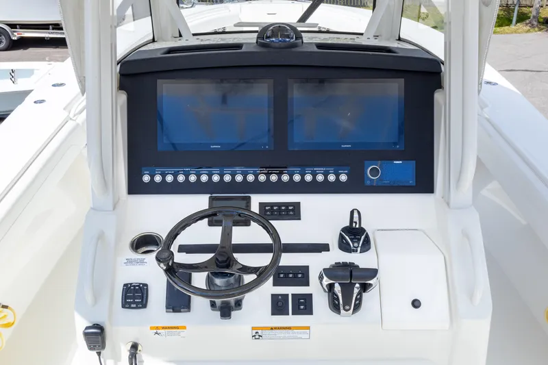 Slide: The Image of 2023 Regulator 34 boat dashboard with dual screens and steering wheel. - 16