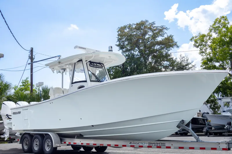 Slide: The Image of 2023 Regulator 34 boat on trailer, white hull, outdoor display. - 2