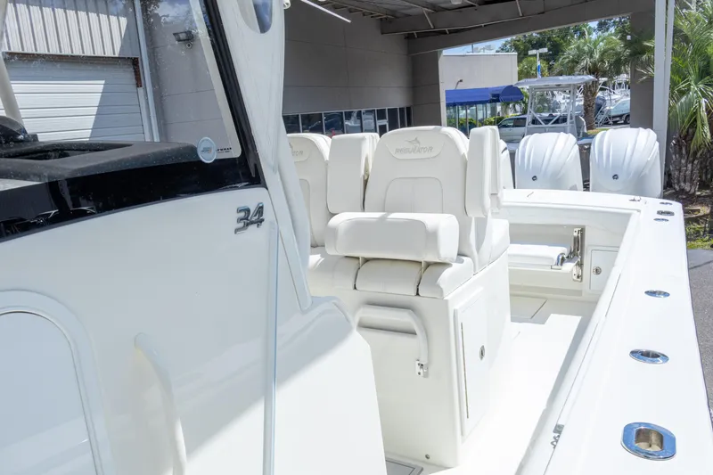 Slide: The Image of 2023 Regulator 34 boat interior with white seating and dual engines. - 22