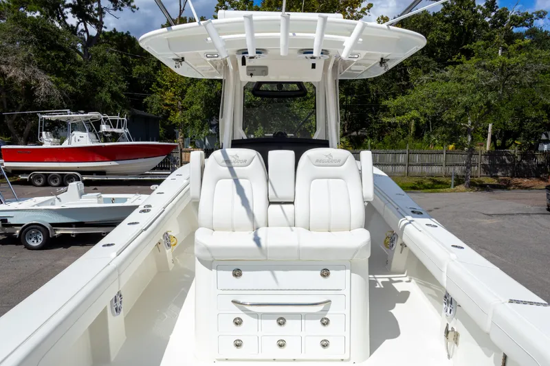 Slide: The Image of 2023 Regulator 34 boat interior with white seating and storage drawers. - 27