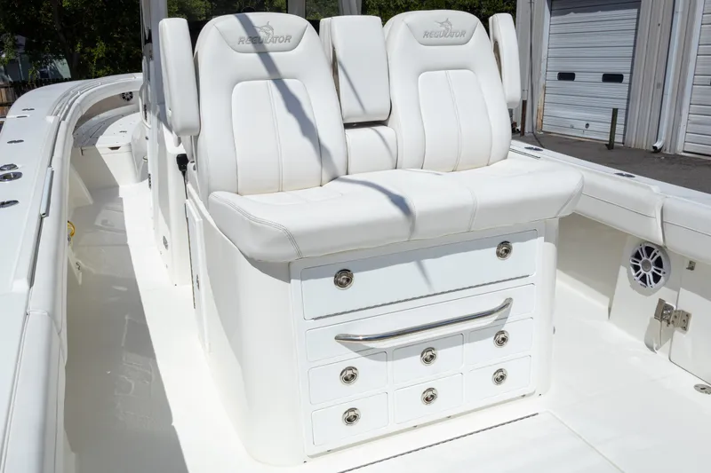 Slide: The Image of 2023 Regulator 34 boat interior with white seating and storage drawers. - 32