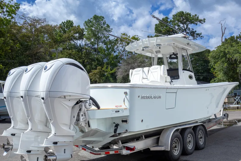 Slide: The Image of 2023 Regulator 34 boat on trailer with triple outboard engines. - 6