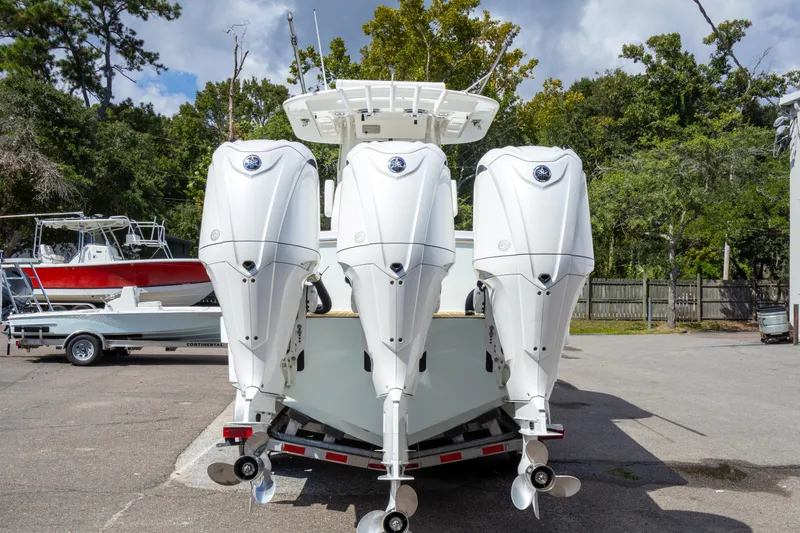 Slide: The Image of 2023 Regulator 34 boat with triple outboard engines in a marina setting. - 9