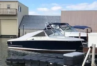 The Image of 1970 Chris-Craft 25 Lancer boat docked at a marina with buildings in the background. - 0