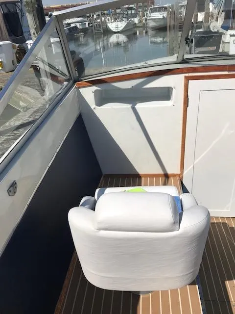 Slide: The Image of 1970 Chris-Craft 25 Lancer boat interior with white seating and wooden flooring. - 15