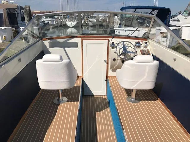 Slide: The Image of 1970 Chris-Craft 25 Lancer boat interior with white seats and wooden flooring. - 4