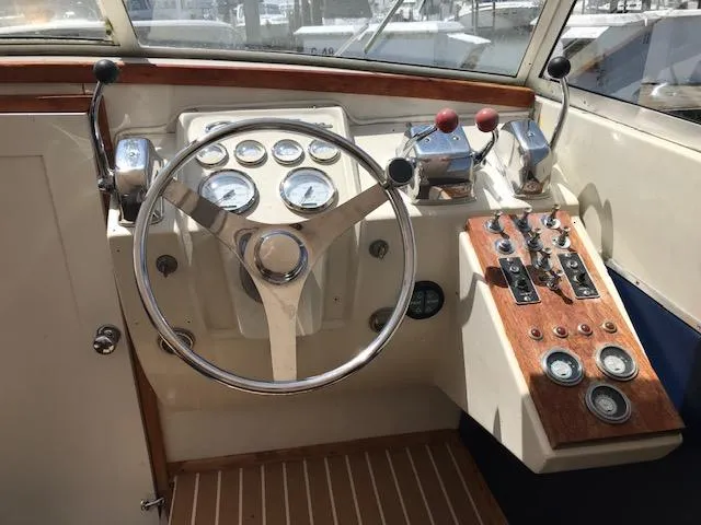 Slide: The Image of 1970 Chris-Craft 25 Lancer boat dashboard with steering wheel and control panel. - 6