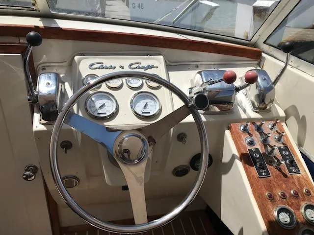 Slide: The Image of 1970 Chris-Craft 25 Lancer boat dashboard with steering wheel and control panel. - 7