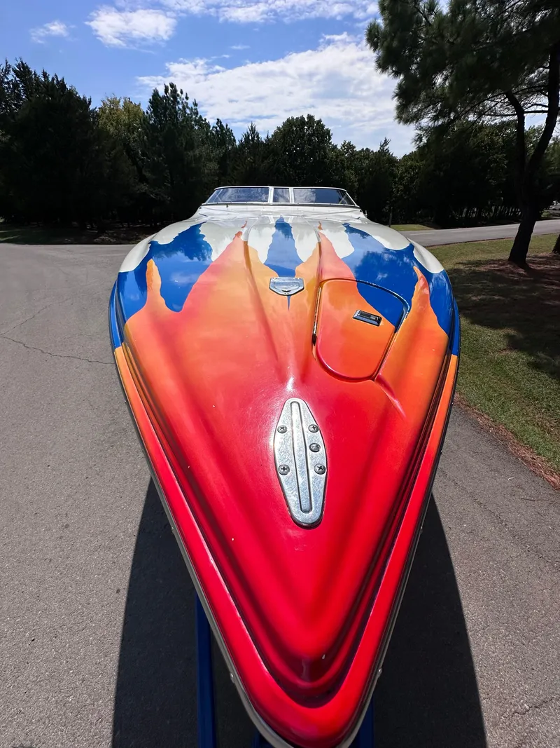 Slide: The Image of 1997 Campion Chase 910 ZRI boat with vibrant red, orange, and blue design. - 6