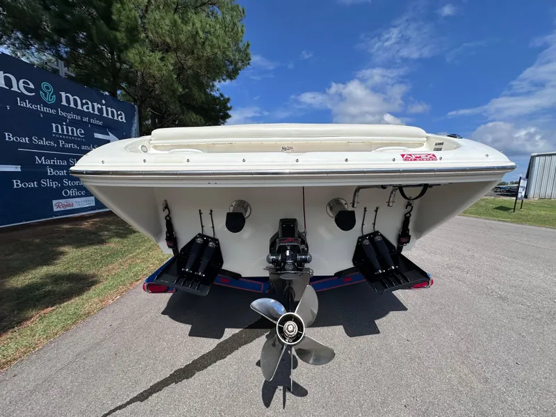 Slide: The Image of 1997 Campion Chase 910 ZRI boat rear view, parked near marina sign. - 7