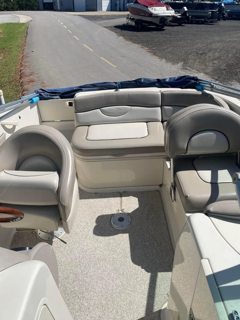 Slide: The Image of 2004 Sea Ray 200 Sundeck interior with beige seating and steering wheel. - 5