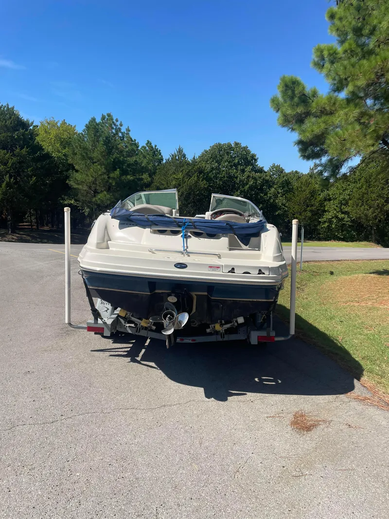 Slide: The Image of 2004 Sea Ray 200 Sundeck boat on trailer, parked on a sunny road. - 6