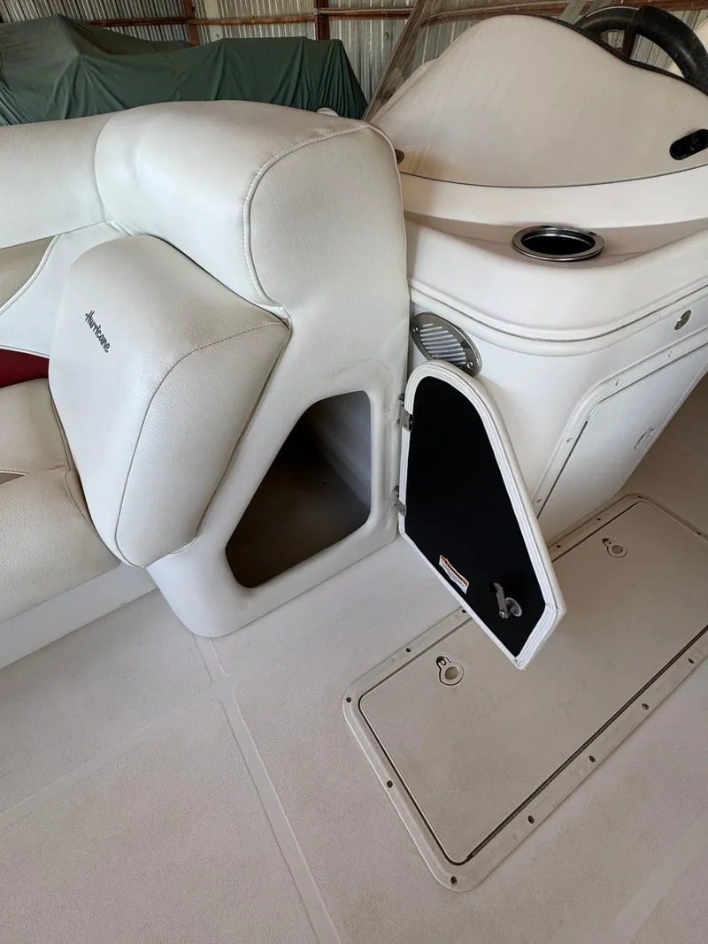 Slide: The Image of 2015 Hurricane Fun Deck 196 interior with open storage compartment and white seating. - 10
