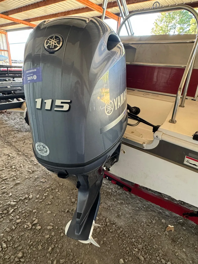 Slide: The Image of 2015 Hurricane Fun Deck 196 with Yamaha 115 outboard motor in a covered area. - 13
