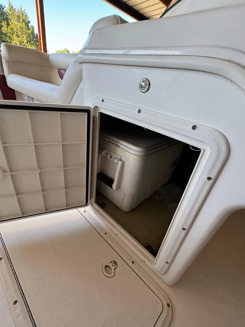 Slide: The Image of Open storage compartment on 2015 Hurricane Fun Deck 196 boat, revealing a cooler inside. - 9